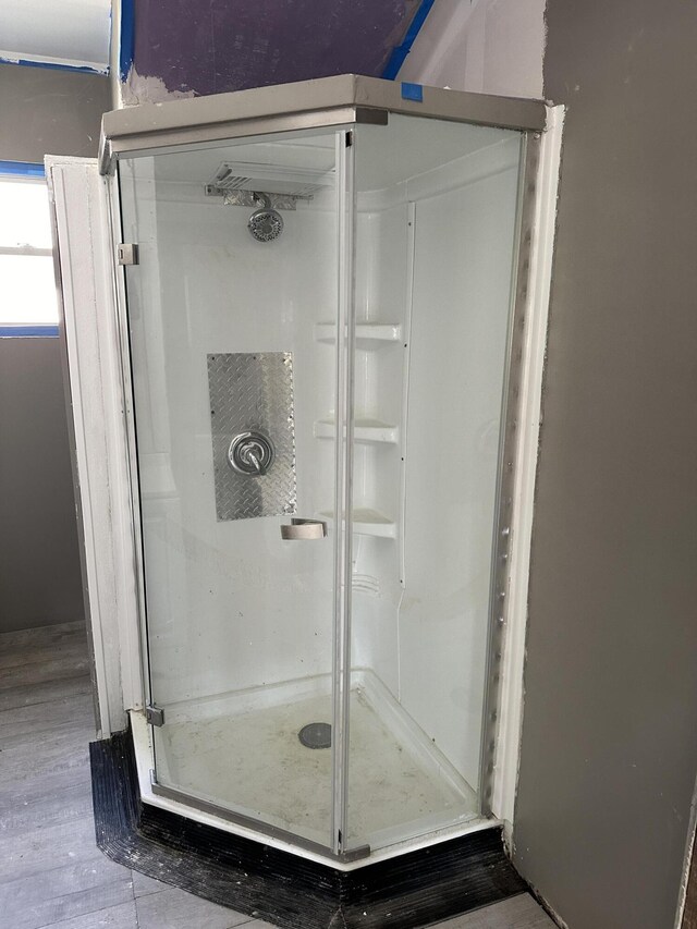 bathroom featuring hardwood / wood-style floors and a shower with shower door