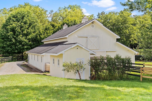 view of side of property featuring an outdoor structure and a lawn