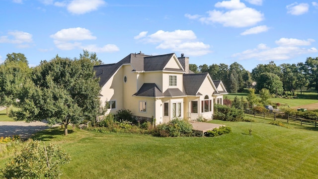 back of property with a yard and a patio area