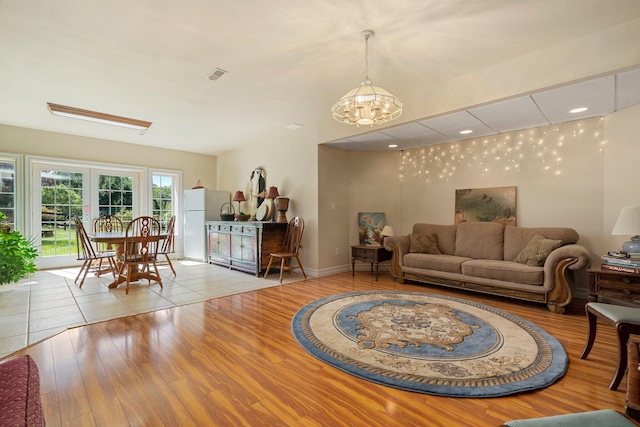 living room featuring a chandelier and light hardwood / wood-style flooring