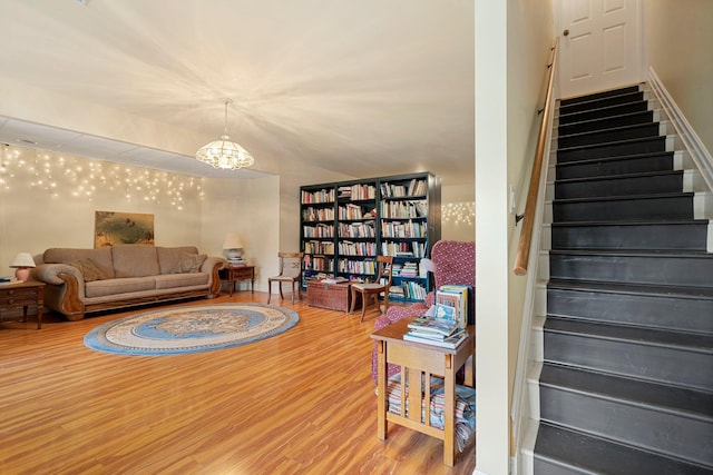 living room with wood-type flooring, vaulted ceiling, and a notable chandelier