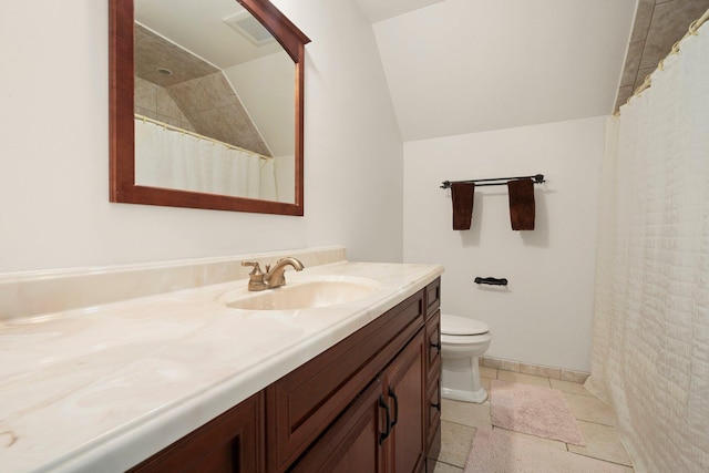 bathroom featuring lofted ceiling, vanity, and toilet