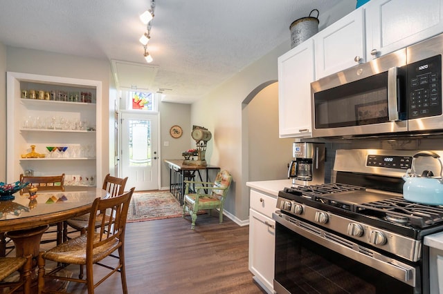 kitchen featuring white cabinetry, dark hardwood / wood-style floors, appliances with stainless steel finishes, and rail lighting