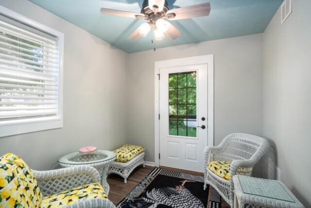 living area with wood-type flooring and ceiling fan