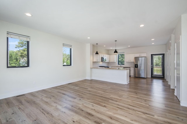 unfurnished living room featuring light hardwood / wood-style flooring and plenty of natural light