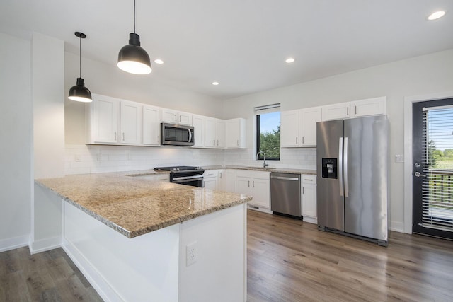 kitchen with kitchen peninsula, sink, white cabinets, and stainless steel appliances