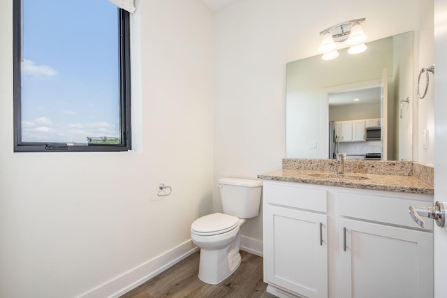 bathroom with hardwood / wood-style floors, vanity, toilet, and plenty of natural light