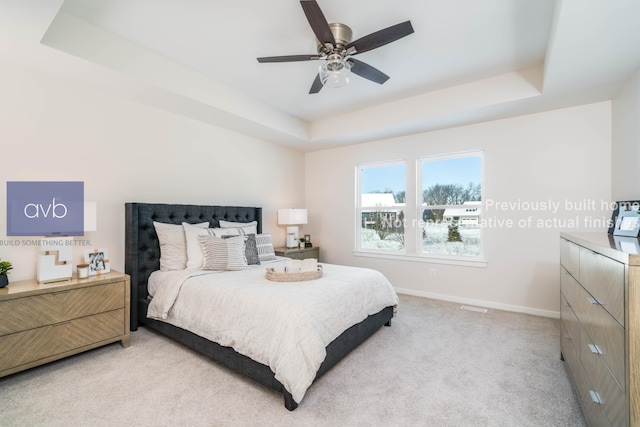 carpeted bedroom with ceiling fan and a tray ceiling