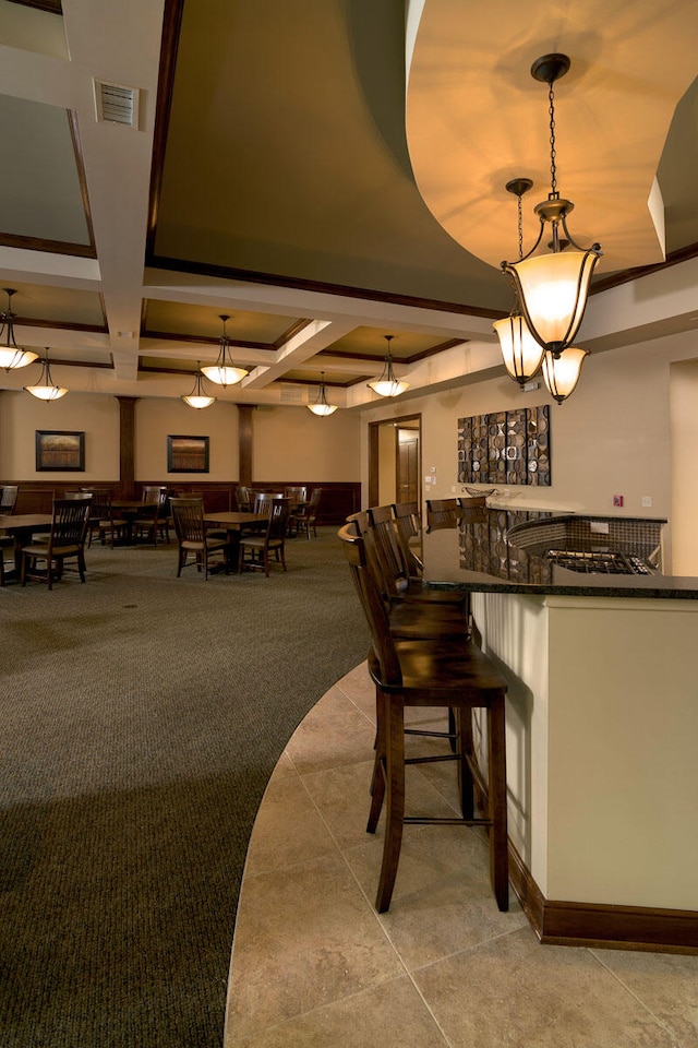 bar featuring decorative light fixtures, beamed ceiling, and coffered ceiling