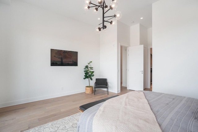 bedroom with a towering ceiling and light wood-type flooring