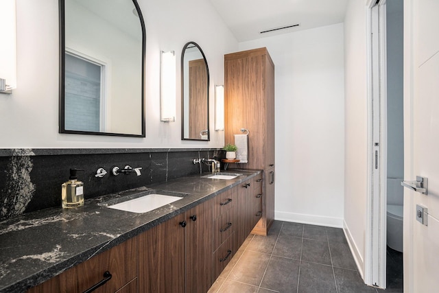 bathroom featuring tile patterned flooring, backsplash, vanity, and toilet