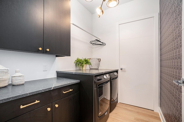 laundry area with cabinets, separate washer and dryer, and light hardwood / wood-style floors