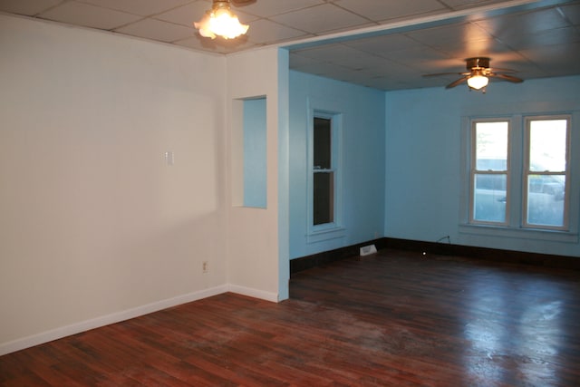 spare room featuring ceiling fan, dark hardwood / wood-style flooring, and a paneled ceiling