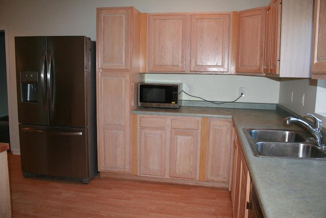 kitchen with sink, light brown cabinetry, refrigerator with ice dispenser, and light wood-type flooring