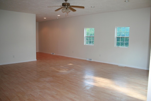 unfurnished room featuring ceiling fan, a textured ceiling, and light hardwood / wood-style floors