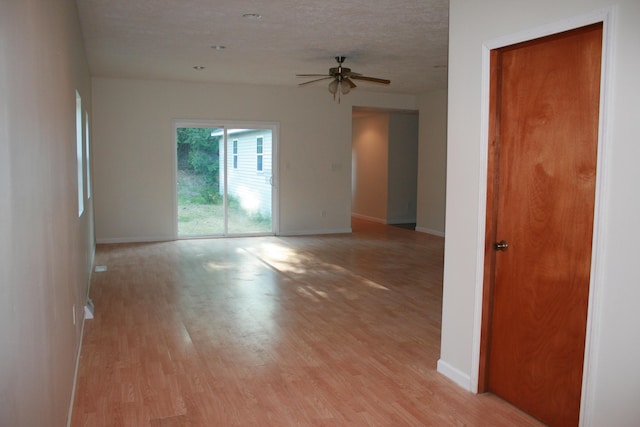 unfurnished room with ceiling fan, a textured ceiling, and light hardwood / wood-style flooring