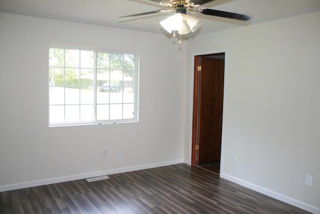 unfurnished room featuring dark wood-type flooring, a wealth of natural light, and ceiling fan