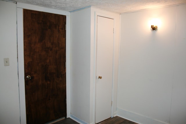 interior space with dark wood-type flooring and a textured ceiling