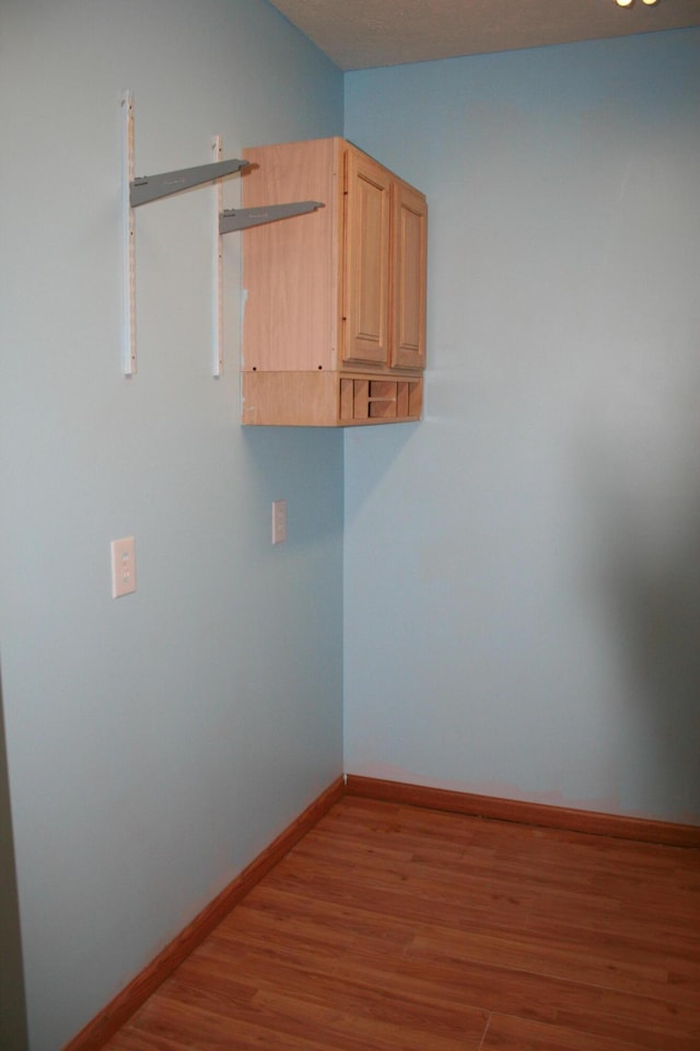 clothes washing area with hardwood / wood-style flooring