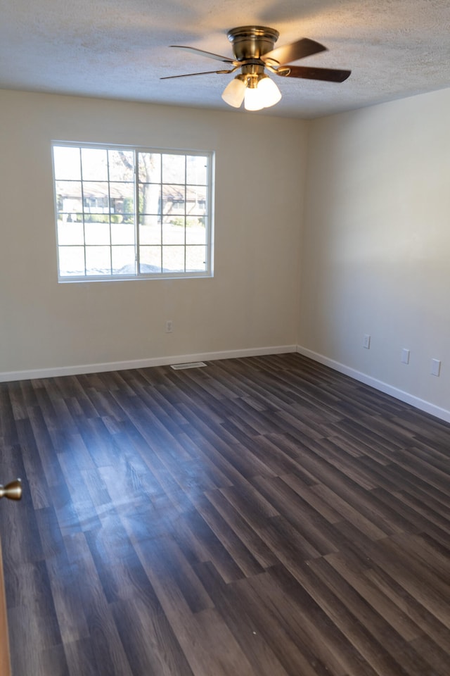 unfurnished room featuring dark hardwood / wood-style flooring, ceiling fan, a wealth of natural light, and a textured ceiling