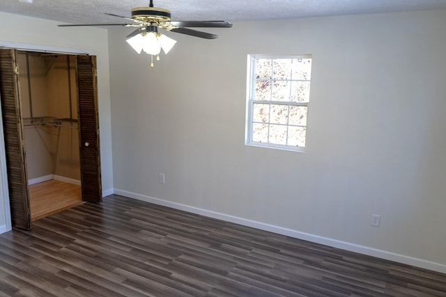 unfurnished bedroom featuring ceiling fan, dark hardwood / wood-style floors, a closet, and a textured ceiling