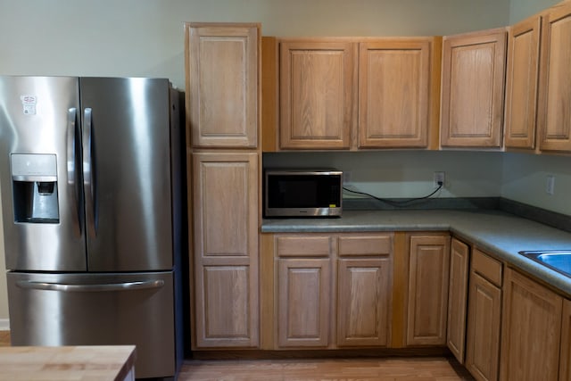 kitchen featuring stainless steel appliances and light hardwood / wood-style floors