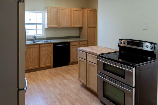 kitchen with appliances with stainless steel finishes, sink, light brown cabinets, and light wood-type flooring