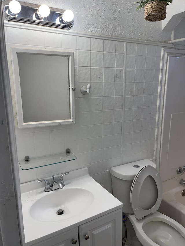 full bathroom featuring shower / tub combination, vanity, toilet, and tile walls