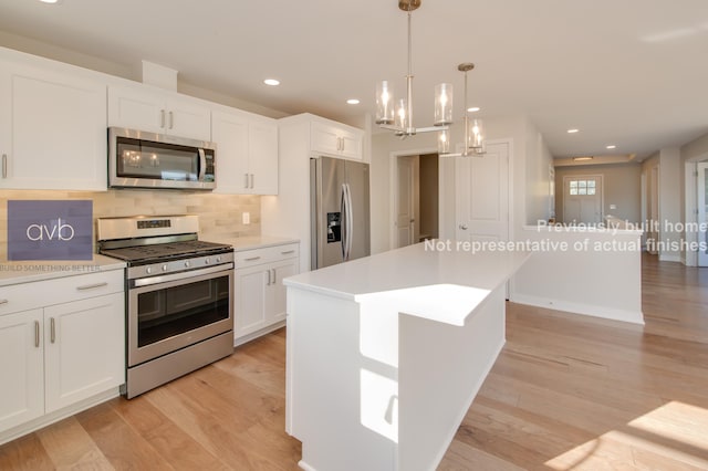 kitchen featuring white cabinetry, light hardwood / wood-style floors, a center island, and appliances with stainless steel finishes