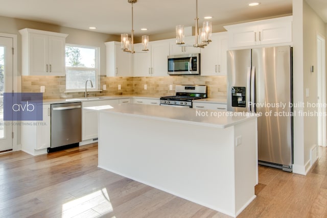 kitchen featuring white cabinetry, appliances with stainless steel finishes, a center island, and decorative light fixtures