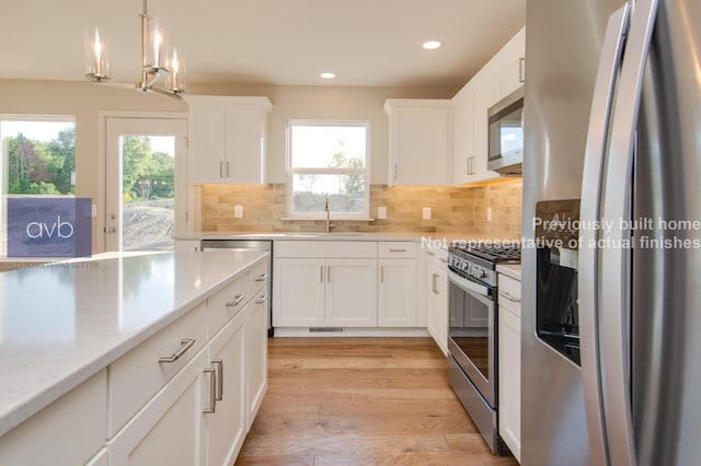 kitchen with sink, light hardwood / wood-style flooring, appliances with stainless steel finishes, tasteful backsplash, and white cabinets