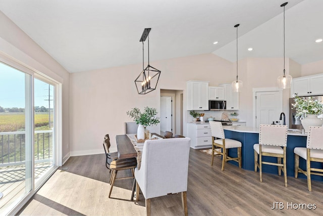 dining room featuring lofted ceiling, a chandelier, and dark wood-type flooring