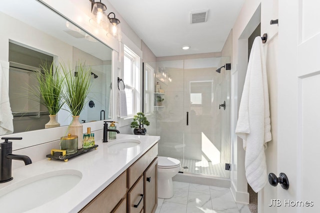 bathroom with vanity, toilet, and a shower with door