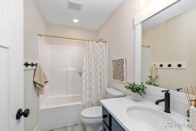 full bathroom with hardwood / wood-style floors, shower / tub combo with curtain, vanity, and toilet