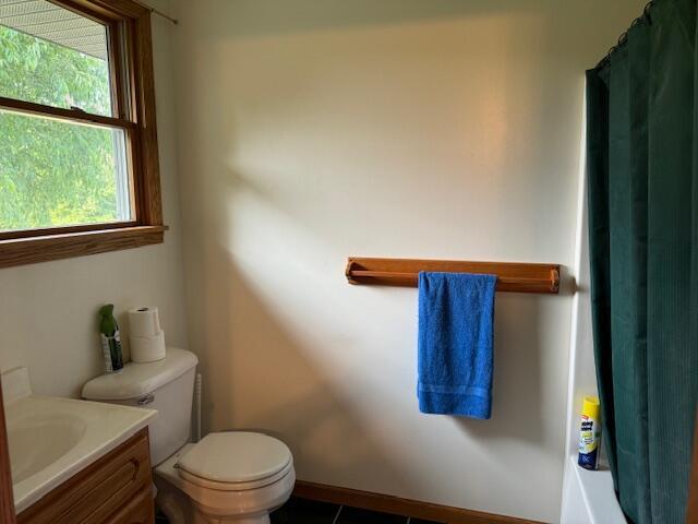 full bathroom with shower / bath combo, toilet, and vanity