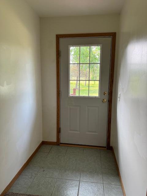 doorway to outside with light tile floors