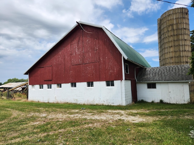 view of property exterior with an outdoor structure and a lawn