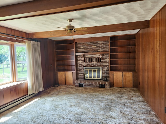 unfurnished living room featuring built in features, wooden walls, a fireplace, carpet, and baseboard heating