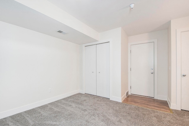 unfurnished bedroom with light carpet and a closet