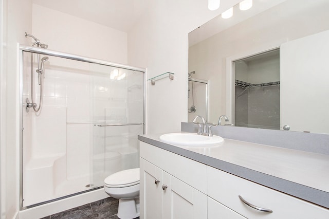 bathroom featuring vanity, a shower with shower door, toilet, and tile patterned floors