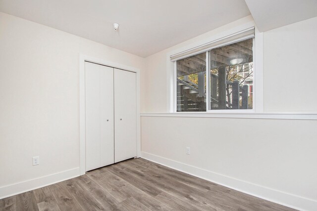 unfurnished bedroom with a closet and hardwood / wood-style flooring