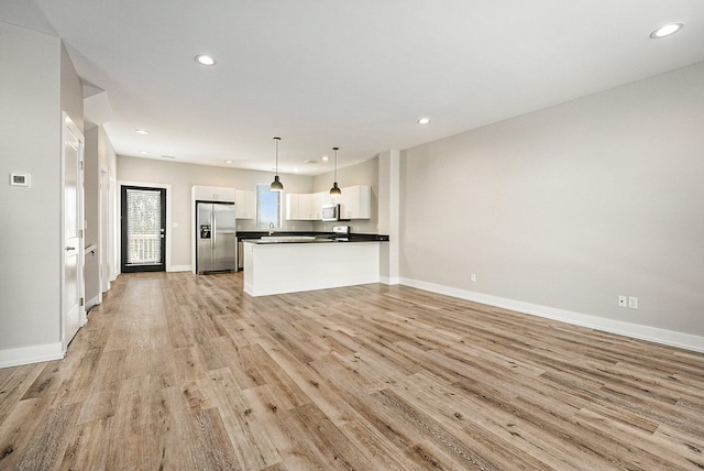 unfurnished living room with light hardwood / wood-style flooring and sink