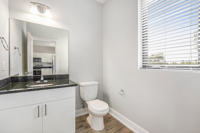 bathroom featuring vanity, toilet, and hardwood / wood-style flooring