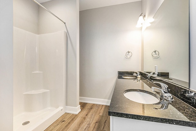 bathroom featuring a shower, vanity, and hardwood / wood-style flooring