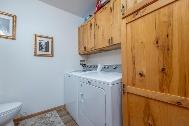 laundry area with washing machine and dryer and light wood-type flooring