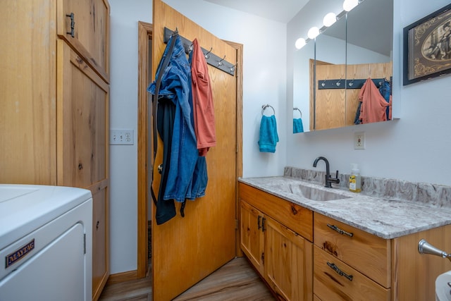 bathroom featuring washer / clothes dryer, vanity, and wood-type flooring