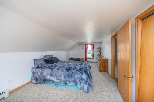 carpeted bedroom featuring a baseboard radiator and vaulted ceiling