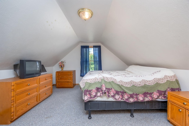 carpeted bedroom featuring vaulted ceiling and a textured ceiling