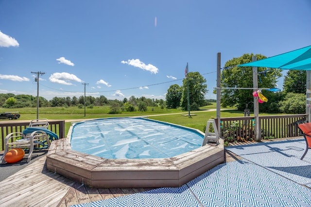 view of swimming pool featuring a deck and a lawn