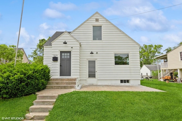 rear view of property with a yard and a patio area